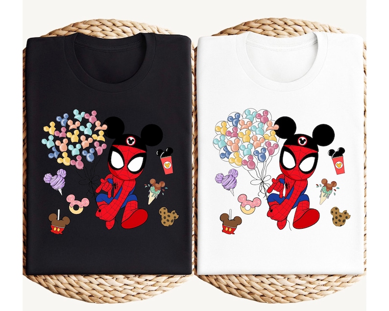 Puede incluir: Camisetas negras y blancas con un personaje de dibujos animados de Spider-Man con orejas de Mickey Mouse. El dise&ntilde;o incluye globos de colores con forma de Mickey Mouse, helados, donuts y tazas de caf&eacute;. Las camisetas se muestran sobre una superficie tejida.