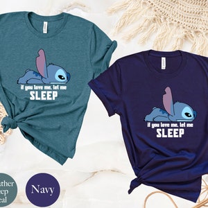 K&ouml;nnte beinhalten: Zwei T-Shirts mit einer blauen Comicfigur. Die Figur liegt mit dem Text "if you love me, let me SLEEP" darunter. Die T-Shirts sind in den Farben heidefarbenes Tiefblau und marineblau.