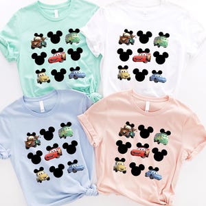 Pu&ograve; includere: Quattro t-shirt con tema Cars e Topolino. Le magliette sono in azzurro, rosa, bianco e verde chiaro. Ogni maglietta presenta un motivo di orecchie di Topolino e personaggi di Cars.