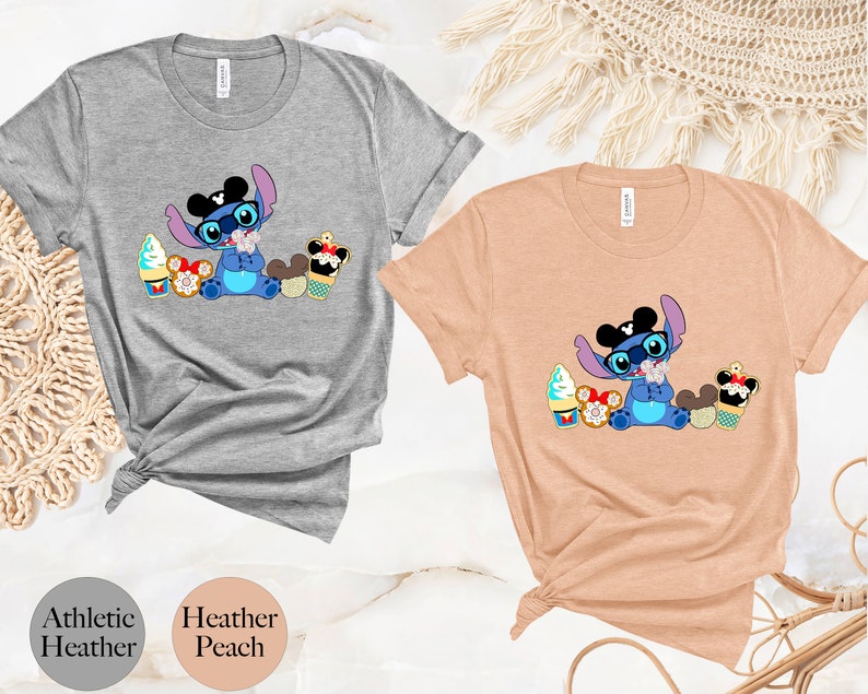 Pode incluir: Camisetas cinza atl&eacute;tico e p&ecirc;ssego heather com um personagem de desenho animado Stitch usando &oacute;culos e chap&eacute;u, cercado por casquinhas de sorvete e sobremesas. As camisetas t&ecirc;m gola redonda e mangas curtas.