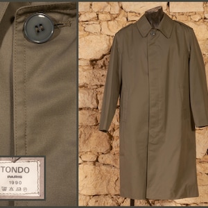 May include: A long, olive green trench coat with a button closure and a label that reads "Tondo Paris 1990".