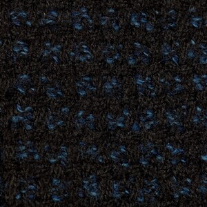 May include: Close-up of a black fabric with a blue flecked pattern. The fabric has a soft, fuzzy texture.