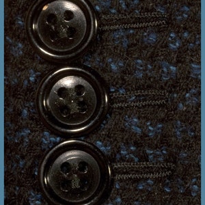 May include: Four black buttons with four holes each, arranged vertically on a dark blue and black fabric.
