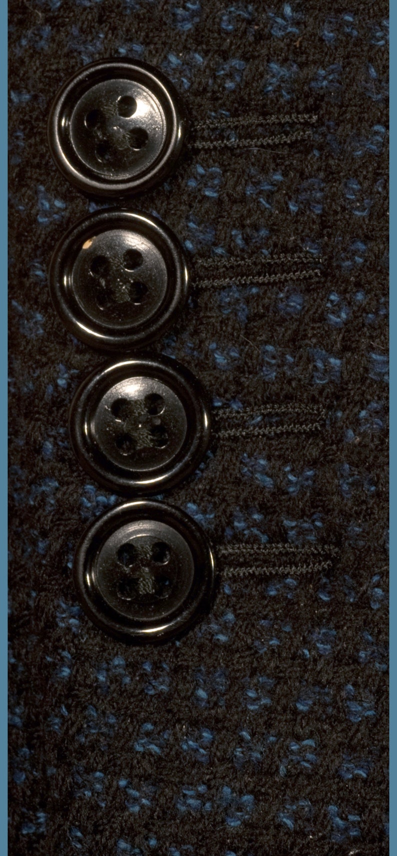 May include: Four black buttons with four holes each, arranged vertically on a dark blue and black fabric.