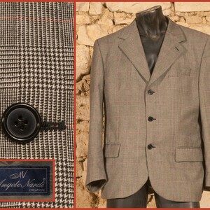 Könnte beinhalten: Ein brauner und grauer karierter Blazer mit drei schwarzen Knöpfen. Der Blazer hat ein Etikett mit der Aufschrift "Angelo Nardi Creation".