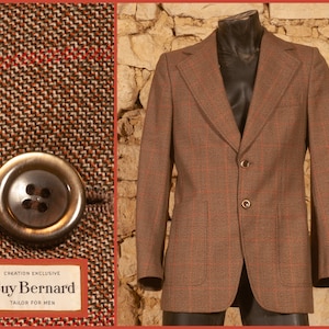 May include: A brown blazer with a subtle red grid pattern, featuring two front buttons, two patch pockets, and wide lapels. A close-up shows the textured fabric, a dark brown button, and a label reading Creation Exclusive Guy Bernard Tailor for Men.