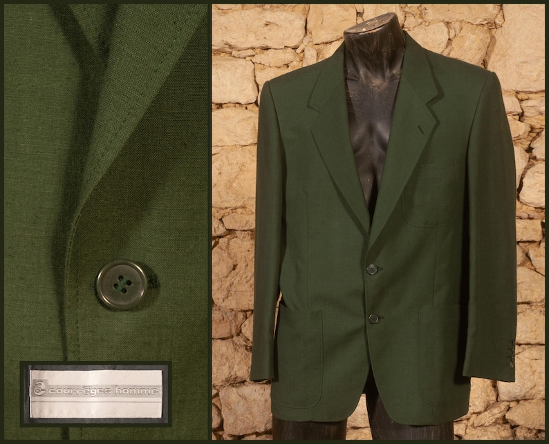 May include: A dark green blazer with two buttons and two front pockets. The blazer is displayed on a mannequin against a stone wall background. The left side of the image shows a close-up of the blazer's fabric and a button.