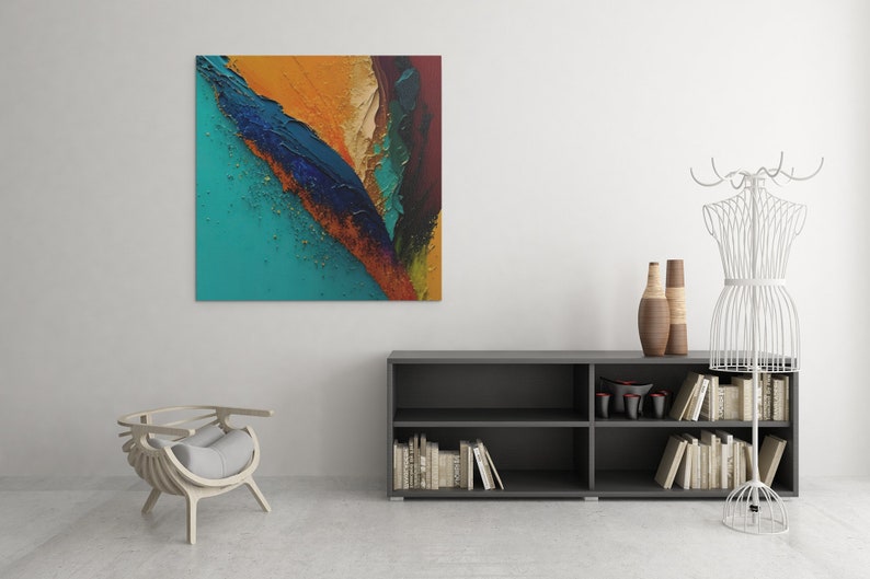 May include: Abstract painting with a teal, blue, gold, and orange color scheme. The painting is hanging on a white wall above a dark gray bookshelf with books and decorative items.