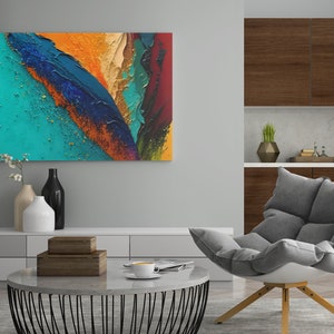May include: Abstract painting with bold strokes of blue, green, orange, and red paint. The painting is displayed on a wall in a living room setting with a gray armchair and a coffee table.