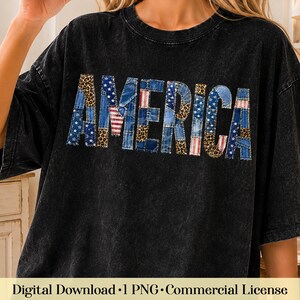 Puede incluir: Una camiseta negra con efecto lavado al ácido que presenta la palabra AMERICA en letras grandes. Las letras están rellenas con un diseño de patchwork de mezclilla azul, rayas rojas y blancas, estrellas blancas sobre azul y estampado de leopardo.