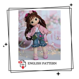 May include: A handcrafted crochet doll with brown hair, dressed in a pink jacket, denim shorts with floral details, and pink shoes. The doll has a flower crown and a small green purse. The image includes the text "ENGLISH PATTERN".