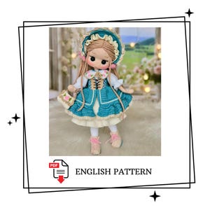 Op de afbeelding: Een handgemaakte gehaakte pop met een teal jurk, bijpassende muts en roze schoenen. De pop heeft lang bruin haar en draagt een kleine handtas. De tekst "ENGLISH PATTERN" is zichtbaar in de afbeelding.