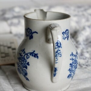 Puede incluir: Jarra de cer&aacute;mica blanca con motivos florales azules. La jarra tiene un asa curva y un pico para verter. El dise&ntilde;o floral azul se repite alrededor del cuerpo y en el asa. Una pieza cl&aacute;sica para servir bebidas.