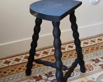 Antieke driepootkruk van gedraaid hout, zwart geverfd – Patina – Rustieke halfronde zitting – Houten sokkeltafel – Bijzettafel – Rustieke landelijke stijl
