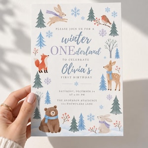 Puede incluir: Una tarjeta de invitación de cumpleaños rectangular blanca con ilustraciones en acuarela de un conejo, zorro, ciervo, oso y petirrojo entre pinos azules y verdes y copos de nieve. El texto dice: PLEASE JOIN US FOR A winter ONEderland TO CELEBRATE Olivia's FIRST BIRTHDAY SATURDAY, DECEMBER 14 AT 2:00 PM THE ANDERSON RESIDENCE 123 SNOWFLAKE LANE.