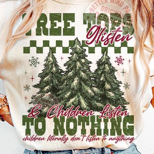 May include: Cream-colored t-shirt with a Christmas tree design. The shirt features the text "TREE TOPS Listen & Children Listen TO NOTHING" in green and burgundy. The phrase "children literally don't listen to anything" is also included.