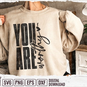 May include: A beige sweatshirt with the words "YOU ARE worthy" printed in black. The text is arranged vertically and in a handwritten font. The sweatshirt is a digital download.