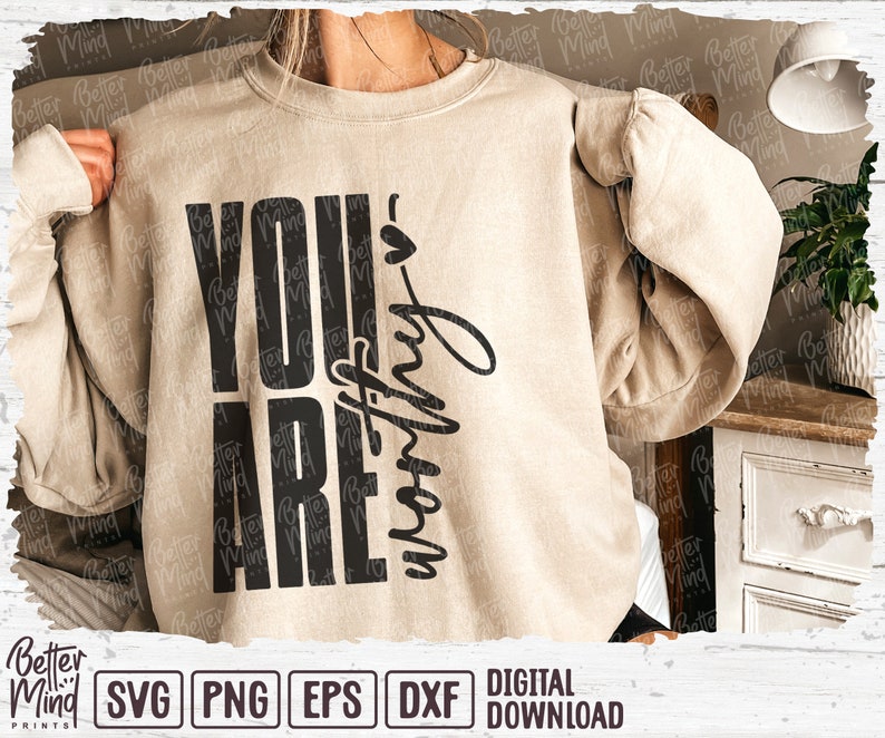 May include: A beige sweatshirt with the words "YOU ARE worthy" printed in black. The text is arranged vertically and in a handwritten font. The sweatshirt is a digital download.