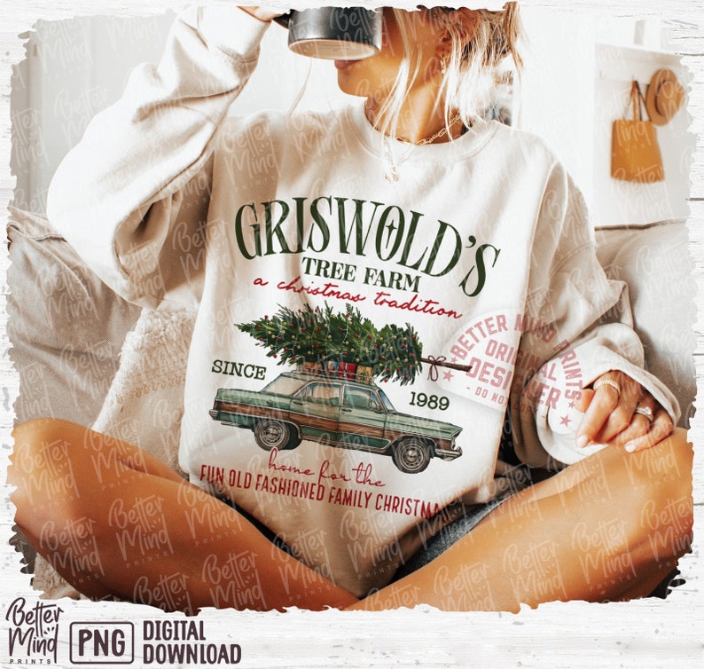 May include: Cream-colored sweatshirt with a graphic of a vintage green car carrying a Christmas tree. The text reads "Griswold's Tree Farm, a Christmas tradition, since 1989." The design includes the phrase "home for the fun old fashioned family Christmas."