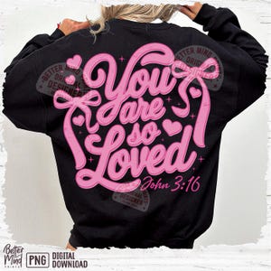 May include: A black sweatshirt with a pink graphic design that says "You are so Loved" with a heart and a bow. The text "John 3:16" is also included in the design.