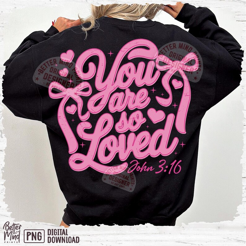 May include: A black sweatshirt with a pink graphic design that says "You are so Loved" with a heart and a bow. The text "John 3:16" is also included in the design.