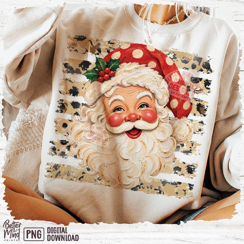 May include: A beige crewneck sweatshirt featuring a graphic of Santa Claus wearing a red hat with white polka dots and a sprig of holly. The design is set against a background of horizontal stripes with a black and tan leopard print pattern.