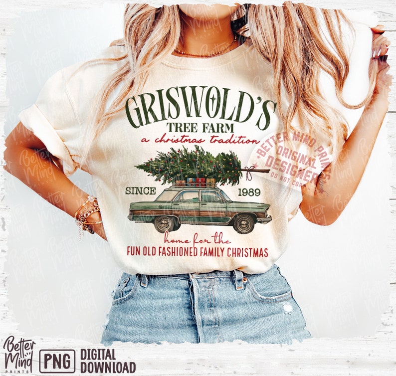 May include: Cream-colored t-shirt featuring a graphic of a green car carrying a Christmas tree, with the text "Griswold's Tree Farm" and "Since 1989". The shirt also includes the phrase "home for the fun old fashioned family Christmas".