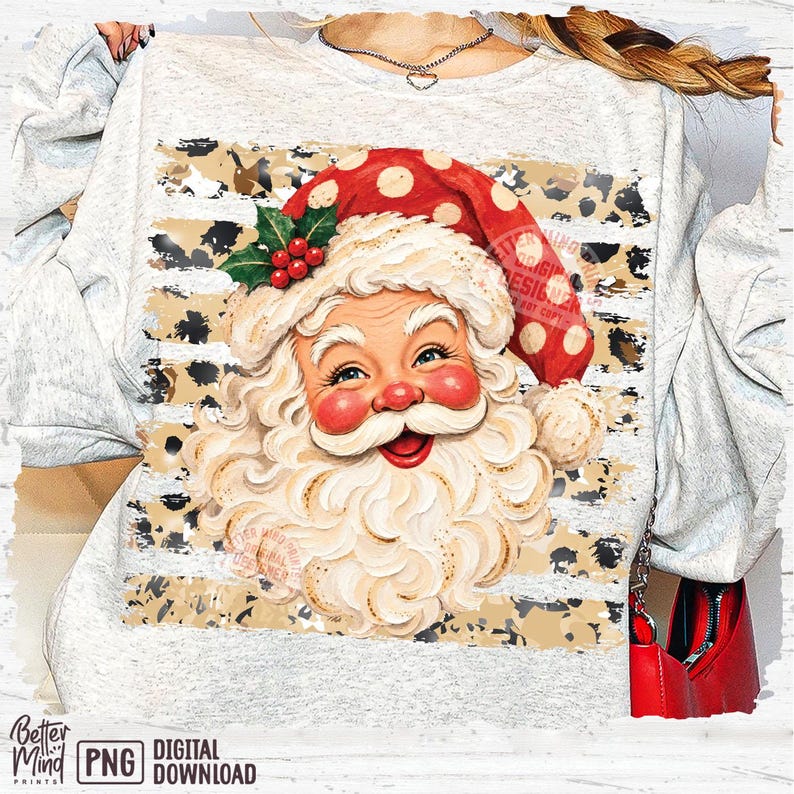 May include: A light gray heathered sweatshirt featuring a graphic of Santa Claus with a white beard, red cheeks, and a red hat with white polka dots. The design includes a background of horizontal stripes with a black and tan leopard print pattern.