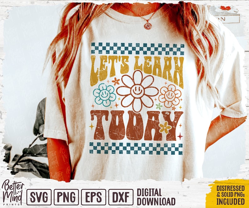 May include: A white t-shirt with a retro-style graphic that says "Let's Learn Today" in colorful letters with flowers and stars. The graphic is surrounded by a checkered border.