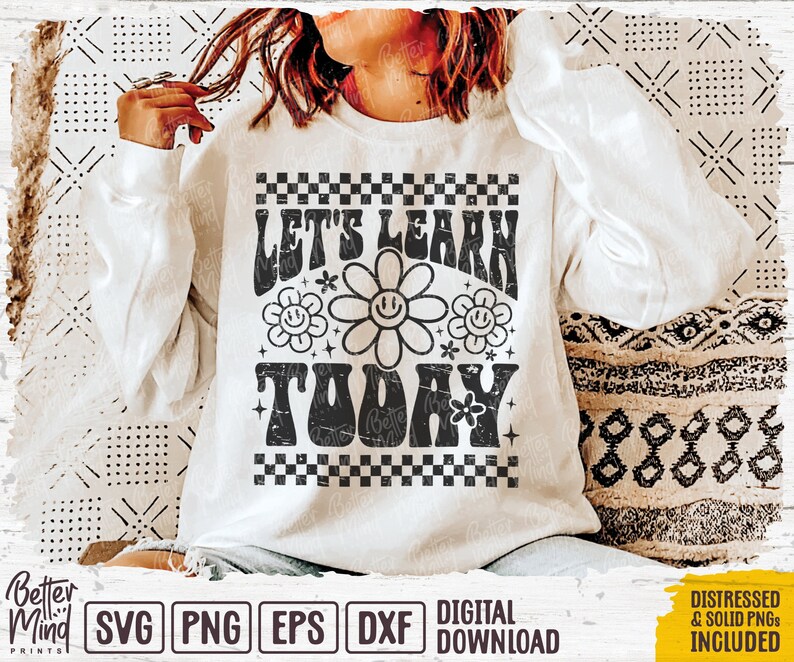 May include: A white sweatshirt with a black graphic design that says "Let's Learn Today" in a retro font with a checkered border and flower accents.
