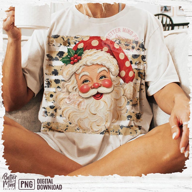 May include: A beige t-shirt featuring a graphic of Santa Claus with a red polka-dot hat, a white beard, and a holly sprig. The design is layered over a horizontal striped pattern with a leopard print texture. The text Better Mind Prints is visible.