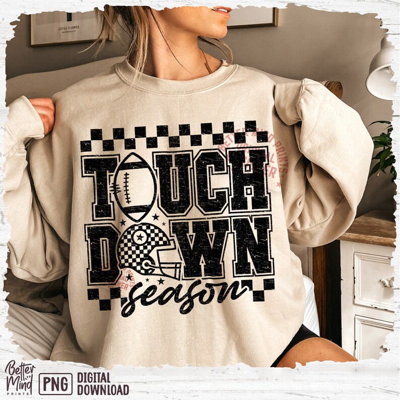 May include: A beige sweatshirt with a black graphic print that says "Touchdown Season" with a football and a helmet. The graphic has a distressed look.