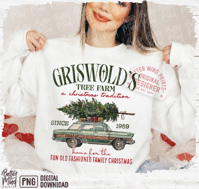 May include: White sweatshirt with a graphic featuring the text "GRISWOLD'S TREE FARM a christmas tradition" and a vintage car carrying a Christmas tree. The design includes the year "1989" and the phrase "home for the FUN OLD FASHIONED FAMILY CHRISTMAS."