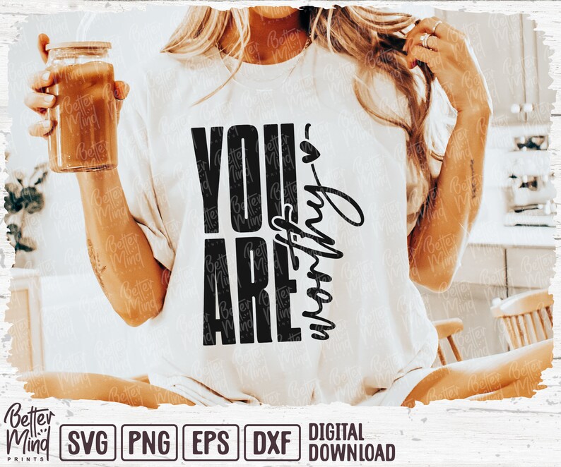 May include: White t-shirt with the text "YOU ARE worthy" in black. The shirt is a digital download. A glass jar with a wooden lid is held in the left hand.