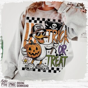 May include: A gray sweatshirt featuring a cartoon duck wearing sunglasses and a hat that says "Spooky Dude." The duck holds a jack-o'-lantern and a "Trick or Treat" sign. The design includes a checkered pattern and a skull and crossbones.
