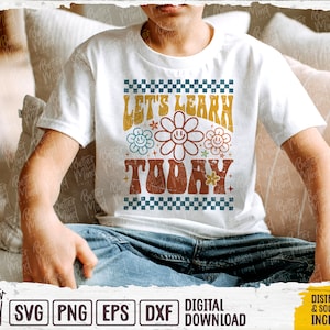 May include: A white t-shirt with a retro design featuring the text "Let's Learn Today" in a colorful, groovy font with flower accents.