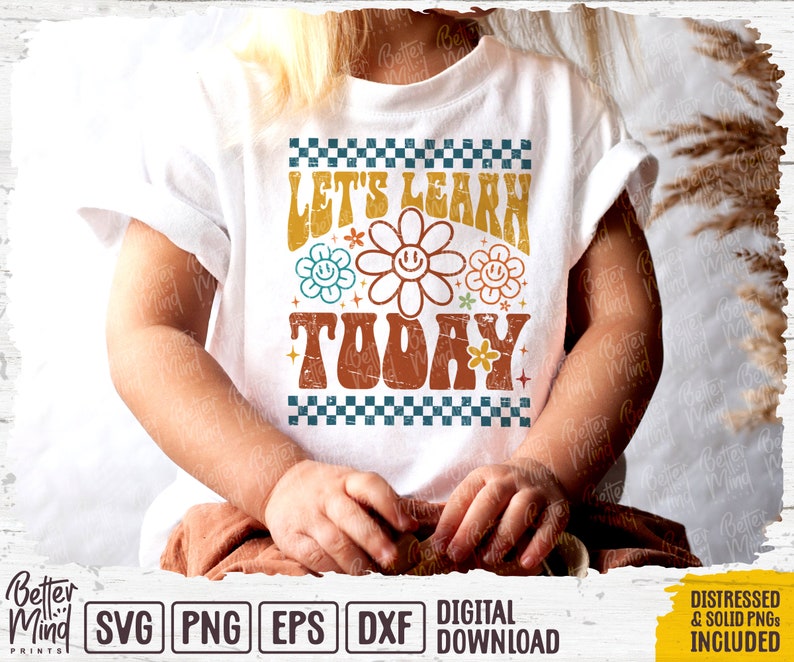 May include: A white t-shirt with a retro-style design featuring the text "Let's Learn Today" in a colorful, distressed font. The design includes a checkered pattern and stylized flowers with smiley faces.