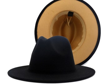 May include: A black fedora hat with a tan felt crown. The hat has a wide brim and a classic fedora shape.
