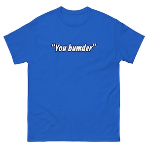 May include: Royal blue t-shirt with the phrase "You bumder" in white, outlined in black. The short-sleeved shirt is made of a soft material.