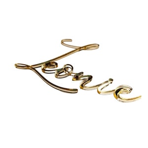 Könnte beinhalten: Goldene kursive Schrift, die den Namen "Lennie" buchstabiert.