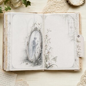 May include: An open journal with light gray pages featuring intricate illustrations. The left page shows an oval mirror reflecting a figure, while the right page displays floral motifs and a moth. A small rectangular tag with a butterfly is attached.