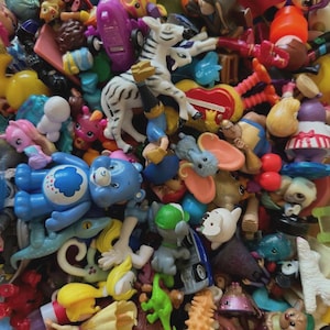 May include: A colorful assortment of children's toys, including figurines, animals, and cartoon characters. The toys are in various colors and sizes, creating a vibrant and playful scene. A zebra figurine is visible.