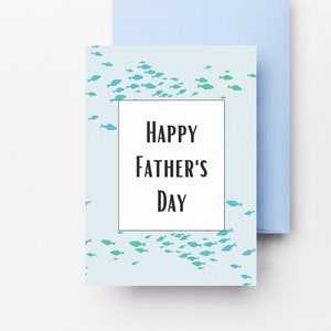 May include: A light blue card with a school of blue and green fish printed on it. The card has a white rectangle with the text "Happy Father's Day" inside.