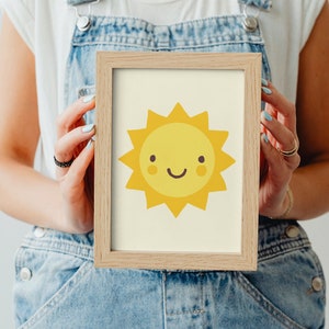 Puede incluir: Una impresi&oacute;n enmarcada de un sol amarillo de dibujos animados con una cara sonriente. El sol tiene una cara amarilla con dos peque&ntilde;as mejillas rojas y una sonrisa con la boca cerrada.