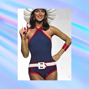 May include: A blue and red crocheted swimsuit with a white belt and a large white hat.
