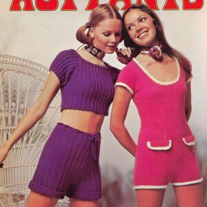May include: Two women modeling knitted clothing. The woman on the left is wearing a purple crop top and matching shorts. The woman on the right is wearing a pink knitted dress with white trim. Both women are wearing necklaces.