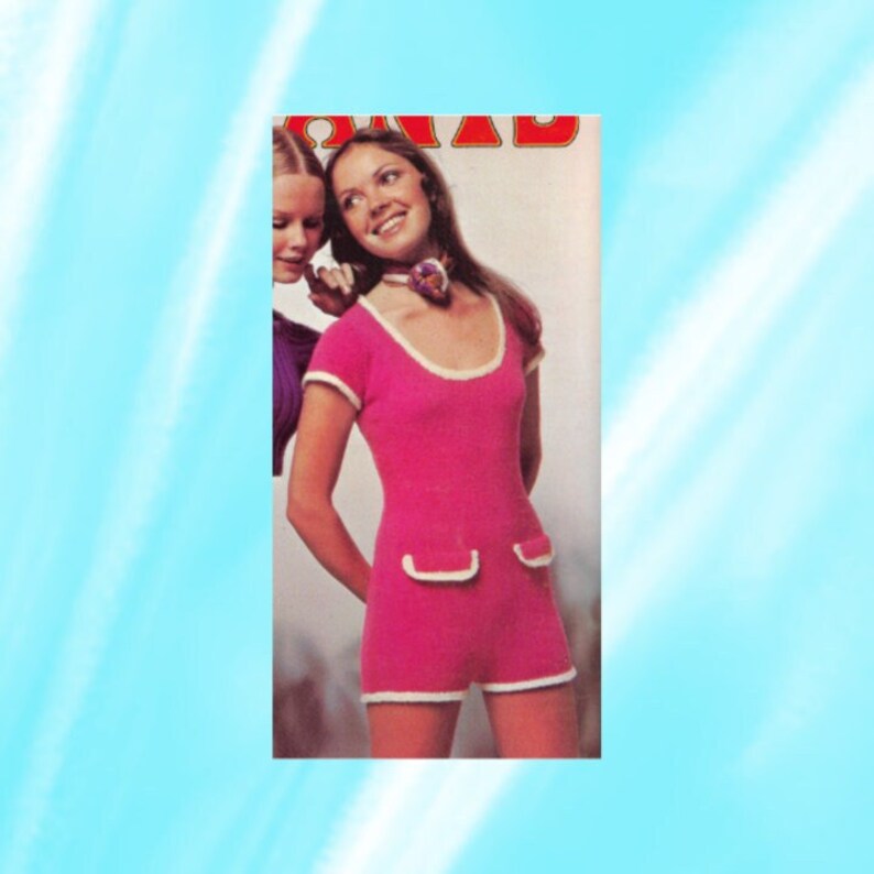 May include: A pink knitted jumpsuit with white trim around the neckline, sleeves, and pockets. The jumpsuit has a scoop neckline and short sleeves.
