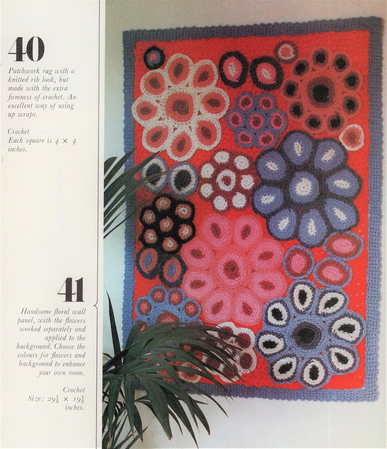 A groovy vintage retro hanging crochet flower rug from 1973 with bright pink, periwinkle blue, bright baby blue, dark blue, white, light purple and magenta flowers with palm plants nearby