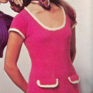 May include: A pink knitted jumpsuit with white trim. The jumpsuit has a scoop neck and short sleeves. It features two patch pockets on the front.