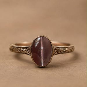 Ring met natuurlijke zalmkleurige kattenoogsteen, vintage gegraveerde sterling zilveren band, ovale cabochon statementsteen.